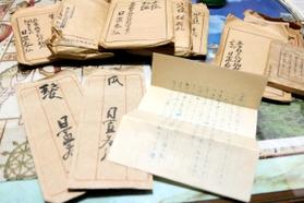 日置春弘さんが書いた遺書や、遺品として残した髪と爪が入った袋＝丹波篠山市畑宮