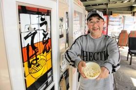 復活したうどん自動販売機とオーナーの藤村学さん＝香美町村岡区長板