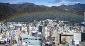 六甲山麓の市街地に低く架かった虹＝４日午前、神戸市役所から（撮影・若林幹夫）