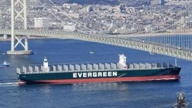 明石海峡大橋の下をくぐり抜けていくメガコンテナ船＝１８日午後、淡路市野島江崎の大阪湾海上交通センターから