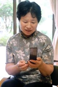 広岡武治さんが亡くなる直前まで使った携帯電話を、大切に残す絹恵さん＝兵庫県佐用町