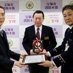 石橋豊消防長から感謝状を受け取る宝塚大劇場の小澤正道さん（中央）と野村洋一郎さん（左）＝宝塚市消防本部