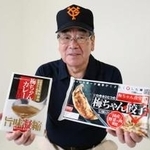 ギョーザやカレーの商品を手に笑顔を見せる梅田茂雄さん＝芦屋市大原町