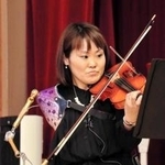 全身を使い、義手でバイオリンを弾く伊藤真波さん＝三木市立豊地小学校