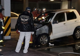前方部分が激しく燃えた軽乗用車＝19日午後７時、垂水区名谷町、餃子の王将名谷店