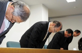 市職員の逮捕を受け、頭を下げる谷口進一丹波市長（左から２人目）ら＝２８日夜、丹波市役所