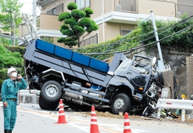ガードレールや電柱をなぎ倒し、横転したトラック＝午後１時１６分、芦屋市山手町
