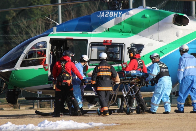 ヘリから降り担架に載せられる救助者とみられる男性＝２８日午後３時１４分、宍粟市山崎町