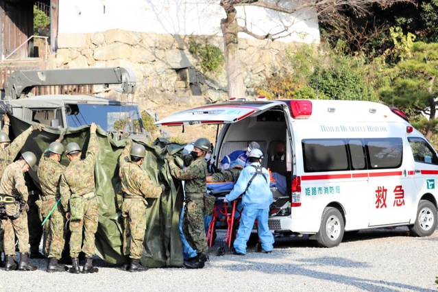 作業中に転落し、救急車に運ばれる自衛隊員＝兵庫県姫路市本町、姫路城