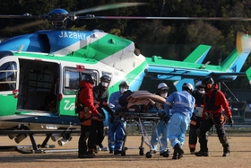 ヘリから降り担架に載せられる救助者とみられる男性＝２８日午後３時１４分、宍粟市山崎町