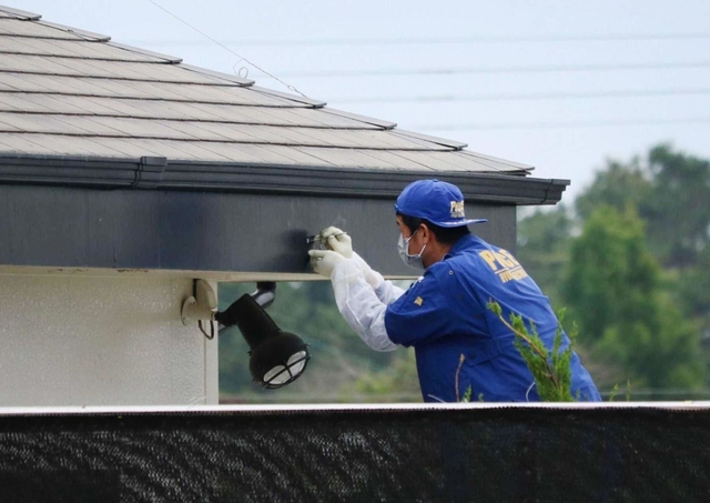 弾痕が見つかった屋根のひさしを調べる捜査員＝２０１７年６月２０日、兵庫県稲美町