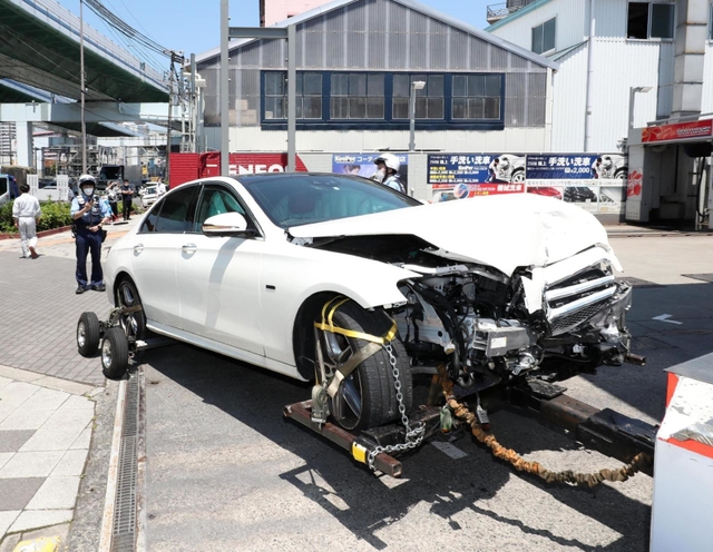 自動車整備工場に突っ込み、大破した乗用車＝２４日午後０時５２分、神戸市長田区梅ケ香町２