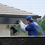 弾痕が見つかった屋根のひさしを調べる捜査員＝２０１７年６月２０日、兵庫県稲美町