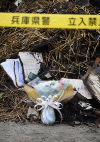 火災現場のがれきに手向けられた花束＝２０２１年１１月２５日、兵庫県稲美町岡