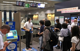 人身事故の影響で運転が見合わせになり、駅員に振り替え輸送の状況などを尋ねる人たち＝１９日午後７時２６分、神戸市灘区、ＪＲ灘駅