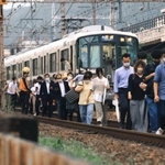 停車した快速電車から降り、線路上を歩いて駅へ向かう乗客ら＝同日午後７時１５分、ＪＲ灘駅近く