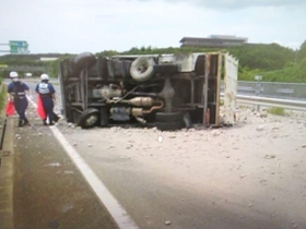 トラックが横転し、荷台からこぼれ出たコンクリート片が道路をふさいだ＝12午前、神戸市西区伊川谷町（兵庫県警提供）