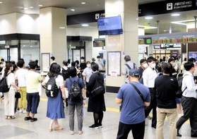 一時運転見合わせとなり、姫路駅の改札口付近で案内を見る利用客ら＝２７日午後６時３７分