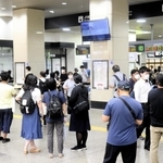 一時運転見合わせとなり、姫路駅の改札口付近で案内を見る利用客ら＝２７日午後６時３７分