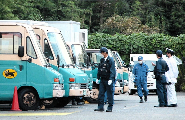 ヤマト運輸神戸北鈴蘭台センターの駐車場周辺を調べる警察官ら＝２０２０年１０月７日、神戸市北区山田町小部