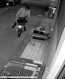 自転車にまたがったまま、メダカの水槽をのぞき込もうとする男（画像の一部を加工しています）