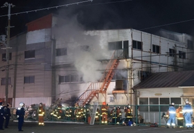 白煙を上げるビル＝１５日午後８時５３分、神戸市長田区本庄町７