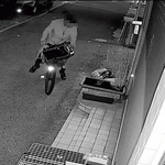 自転車にまたがったまま、メダカの水槽をのぞき込もうとする男（画像の一部を加工しています）