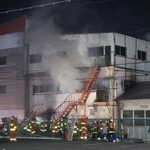 白煙を上げるビル＝１５日午後８時５３分、神戸市長田区本庄町７