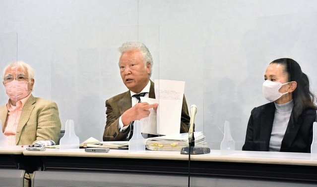 県側の答弁書類を手に憤りを表す木戸一仁さん（中央）＝１日午後、大阪市北区西天満２