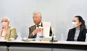 県側の答弁書類を手に憤りを表す木戸一仁さん（中央）＝１日午後、大阪市北区西天満２