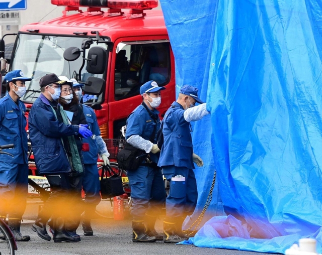 火災があった集合住宅に入る兵庫県警の捜査員ら＝２３日午前、神戸市兵庫区湊町１