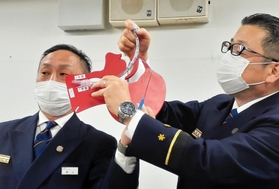 気道確保用チューブの挿管方法を説明する尼崎市消防局の渡辺賢一救急課長（右）ら。あおむけの状態で上側の気管に入れるところを、下側の食道に入れてしまっていた＝尼崎市役所