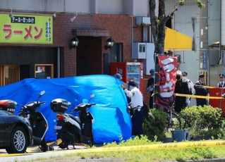 男性が死亡する事件が起き、ブルーシートで覆われた店舗＝２２日午後１時４分、、神戸市長田区東尻池町９