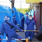 ラーメン店の店主が殺害された事件で、立ち入りを規制して現場の周辺を調べる捜査員ら＝２３日午前、神戸市長田区東尻池町９