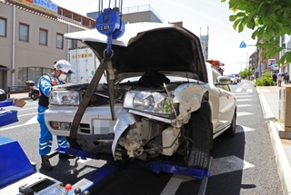 店舗に突っ込んだ後、レッカーされる乗用車＝９日午後０時１３分、西宮市羽衣町（撮影・吉田敦史、画像を一部加工しています）