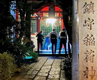さい銭箱の周辺を調べる警察官＝１０日午後１０時３２分、神戸市兵庫区西出町、西出鎮守稲荷神社