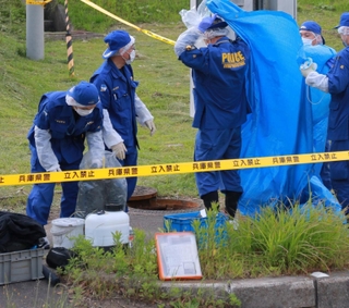 遺棄された乳児の遺体が見つかった下水道を調べる捜査員＝２５日午後５時４７分、丹那篠山市真南条上