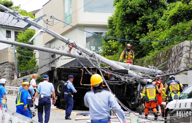 電柱２本をなぎ倒して横転したトラック＝１４日午前、芦屋市山手町