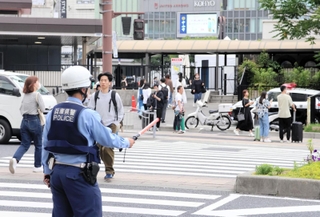 信号機が消えた交差点で交通整理をする警察官＝神戸市中央区