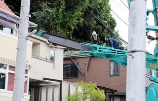 倒れたクレーンの復旧作業にあたる作業員＝１４日午後４時２分、灘区赤松町１