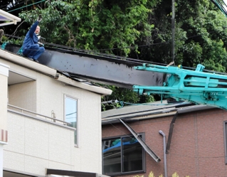 倒れたクレーンの復旧作業にあたる作業員＝１４日午後３時５６分、灘区赤松町１