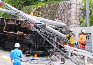 トラックが突っ込み、激しく壊れた電柱とめくれあがったガードレール＝１４日午前、芦屋市山手町