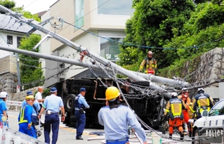 電柱２本をなぎ倒して横転したトラック＝１４日午前、芦屋市山手町