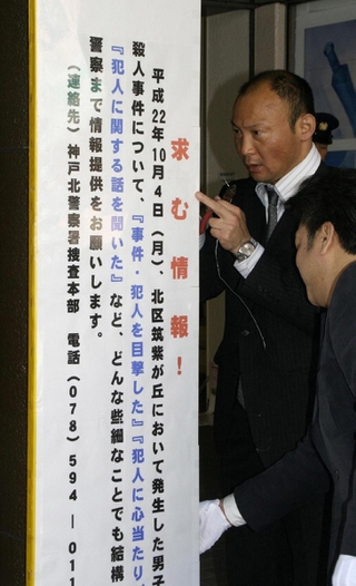 駅前の支柱に看板を取り付ける捜査員＝２０１１年４月、北区甲栄台４、神戸電鉄北鈴蘭台駅