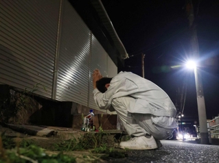 容疑者逮捕の報を聞き、事件現場で泣きながら手を合わせる男性＝４日午後８時３４分、神戸市北区筑紫が丘４