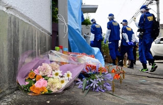 容疑者の自宅へと向かう兵庫県警の捜査員。集合住宅の一角に、花束や菓子が供えられていた＝２４日午後、神戸市西区玉津町居住