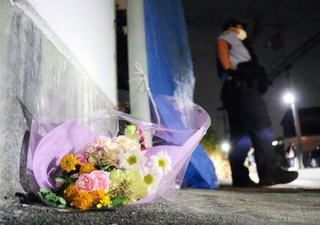 事件が報じられた２３日夜、亡くなった穂坂修ちゃんが住んでいたとされる集合住宅にはブルーシートが張られ、花が手向けられた＝２３日午後８時１０分、神戸市西区玉津町居住