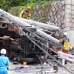 トラックが突っ込み、激しく壊れた電柱とめくれあがったガードレール＝１４日午前、芦屋市山手町