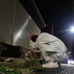 容疑者逮捕の報を聞き、事件現場で泣きながら手を合わせる男性＝４日午後８時３４分、神戸市北区筑紫が丘４