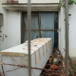 亡くなった男児らが住んでいた住宅の庭。冷蔵庫が放置され、窓にはテープが貼られていた＝２３日午前、神戸市西区玉津町居住